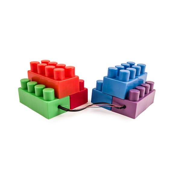 Two brick Lego toy sets sitting side-by-side with a black chord connecting the two.